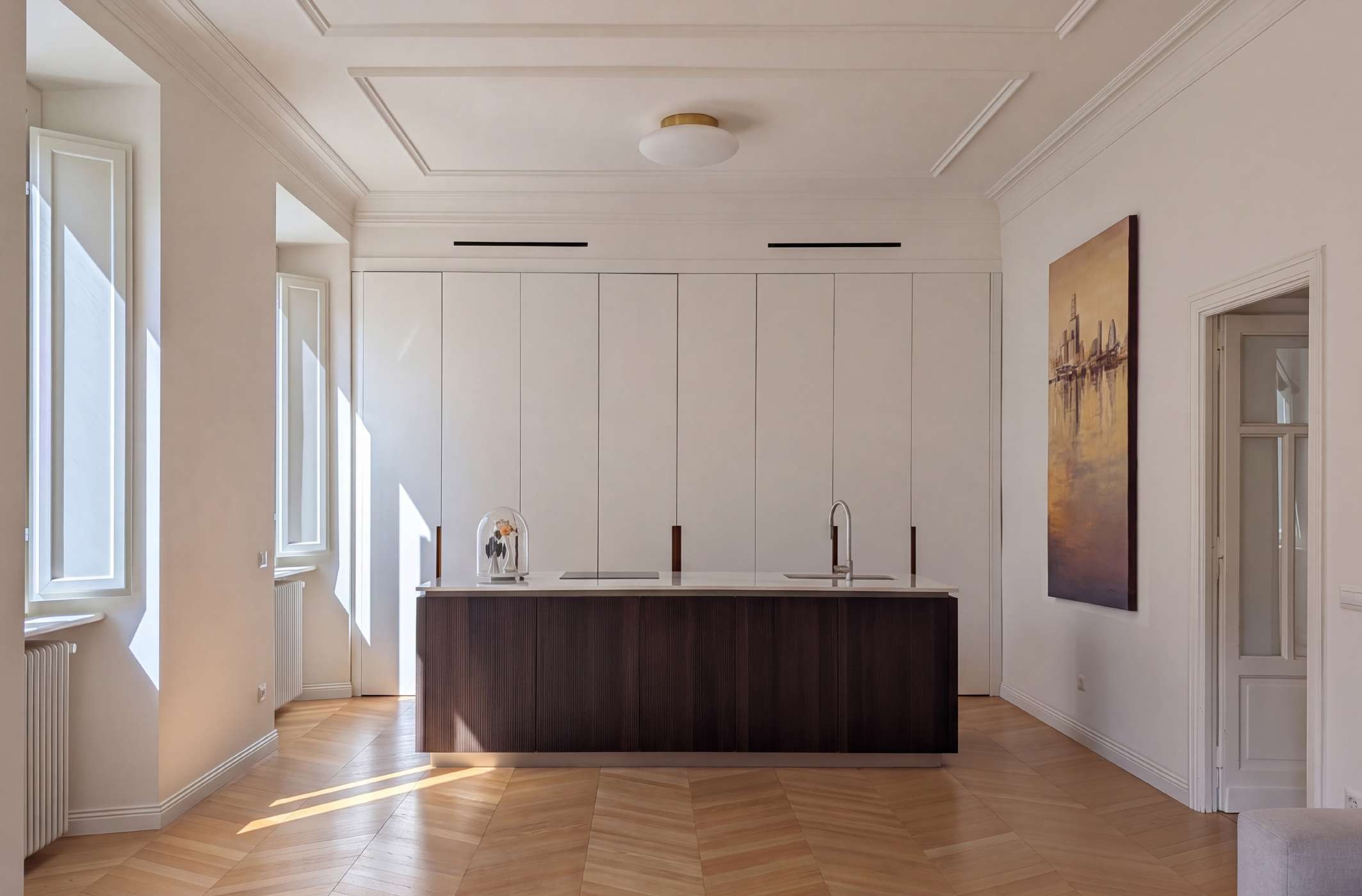 Cucina con isola scura e soffitto storico